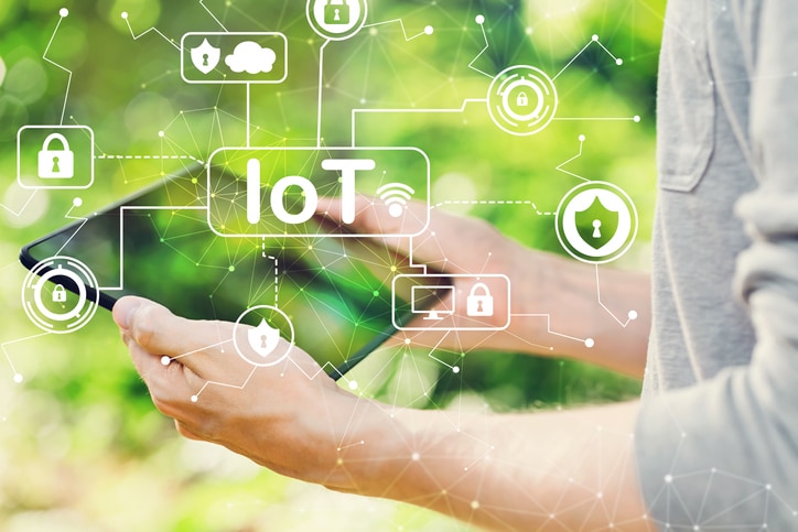 IoT security theme concept with man holding his tablet computer outside in the park